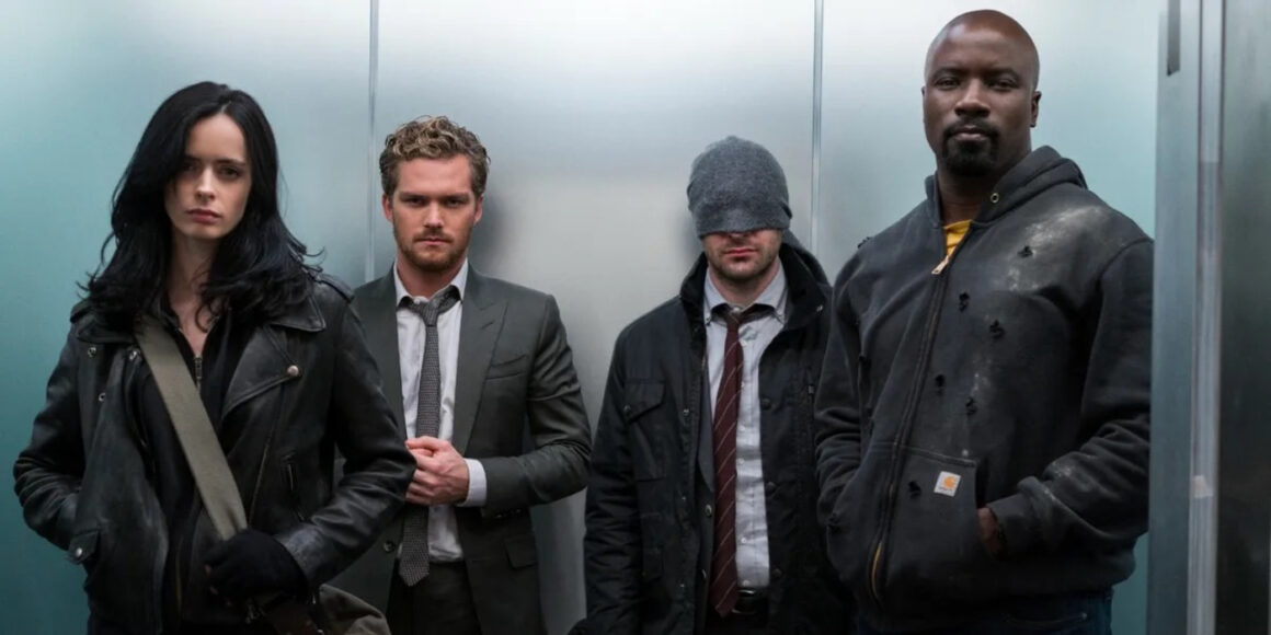 Krysten Ritter as Jessica Jones, Finn Jones as Danny Rand, Charlie Cox as Matt Murdock, and Mike Colter as Luke Cage standing in an elevator in The Defenders | Agents of Fandom