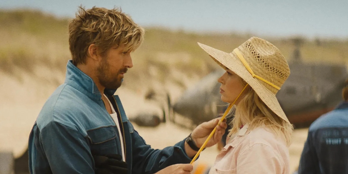 Colt Seavers (Ryan Gosling, left) attempts to woo Jody Moreno (Emily Blunt, right) with his cool-guy stunts as he tightens the rope on her sunhat in The Fall Guy I Agents of Fandom