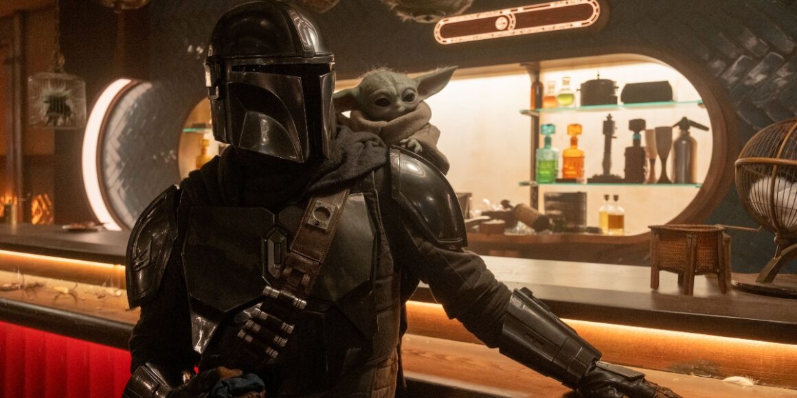 Din Djarin and Grogu in a Star Wars cantina in The Mandalorian and Grogu | Agents of Fandom