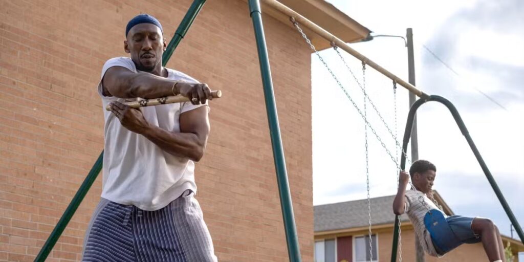 Latif (Mahershala Ali) practicing with a weapon while his son, Qadir (Jahleel Kamara), rides a swing in Your Mother Your Mother Your Mother | Agents of Fandom