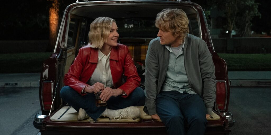 Rhea Seehorn and Owen Wilson sit in the bed of a truck in Stick Season 2 | Agents of Fandom